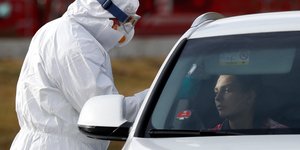 Τσεχία άνδρας με στολή εξετάζει ταξιδιώτη λόγω κορωνοϊού