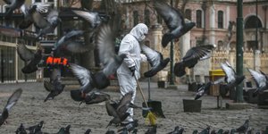 Κορωνοϊός -Ανθρωπος με στολή καθαρίζει πλατεία