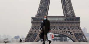 Ζευγάρι περπατά μπροστά από πύργο του Άιφελ