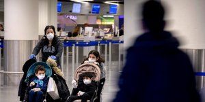 Επιβάτες σε αεροδρόμιο με μάσκες