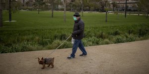 Άνδρας βγάζει βόλτα τον σκύλο του, στην υπό καραντίνα Ισπανία