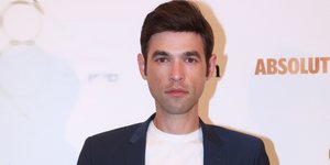 Ο παρουσιαστής Μένιος Φουρθιώτης με σακάκι και λευκό T-Shirt