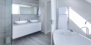 Μπάνιο λευκό με λευκές πετσέτες κρεμασμένες