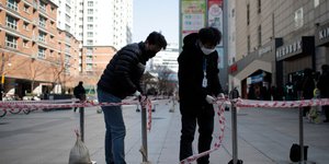 Νεαροί κλείνουν δημόσιο δρόμο με κορδέλες, φορώντας ιατρική μάσκα