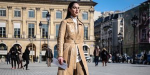 γυναίκα περπατά στην εβδομάδα μόδας με μπεζ φόρεμα