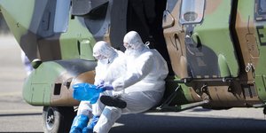 Νοσηλευτικό προσωπικό με στολές και μάσκες σε στρατιωτικό ελικόπτερο