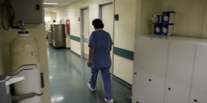 Νοσηλεύτρια περπατάει σε διάδρομο νοσοκομείου
