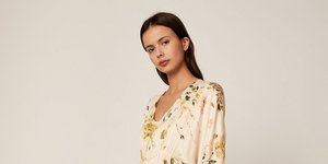 Μοντέλο φοράει μπεζ φόρεμα με λουλούδια