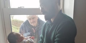 Ο συγκινημένος παππούς κοιτάζει το εγγονάκι του από το παράθυρο