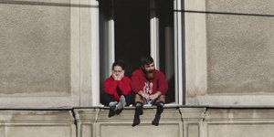 Ζευγάρι στο παράθυρο του σπιτιού του ενώ ισχύουν μέτρα απαγόρευσης κυκλοφορίας λόγω του κορωνοϊού στην Πολωνία