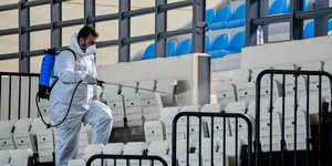 Ανδρας με ειδική στολή απολυμαίνει κερκίδες