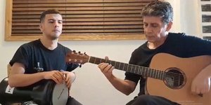 Σωκράτης Μάλαμας τραγουδάει με κιθάρα και δίπλα του είναι ο γιος