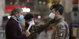 Στρατιώτες και πολίτες με μάσκες για προστασία από τον Κορωνοϊό στην Ιταλία