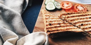 Ψημένο τοστ σε ξύλινη παλέτα με ντομάτα και αγγούρι