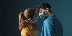 Ζευγάρι με μάσκα για τον κορωνοϊό ετοιμάζεται να φιληθεί