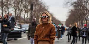 γυναίκα με καφέ πουλόβερ και γυαλιά στην εβδομάδα μόδας