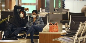 Ζευγάρι με μάσκες σε χώρο αναμονής αεροδρομίου στις ΗΠΑ