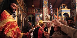 Ιερέας με πιστούς στο «δεύτε λάβετε φως»