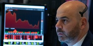 Ανδρας παρακολουθεί σε οθόνη τους δείκτες στο χρηματιστήριο