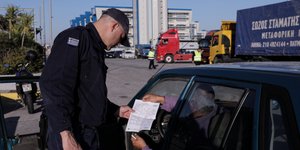 Αστυνομικός διενεργεί έλεγχο στο πλαίσιο του περιορισμού των μετακινήσεων λόγω κορωνοϊού