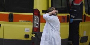 Γιατρός περνά μπροστά από ασθενοφόρο