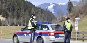 Αστυνομικοί έξω από περιπολικό, φορούν μάσκα και πραγματοποιούν ελέγχους στην Αυστρία