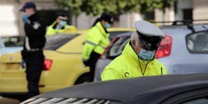 Αστυνομικός κάνει έλεγχο για την τήρηση του μέτρου της απαγόρευσης της κυκλοφορίας