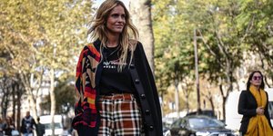 γυναίκα με παντελόνι και ζακέτα στο δρόμο