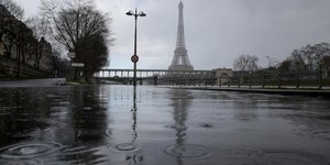 Βρεγμένος δρόμος στο Παρίσι με φόντο τον Πύργο του Άιφελ
