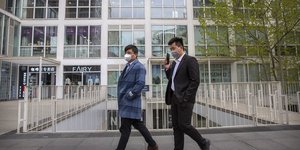 Κινέζοι με μάσκες έξω από κτίριο