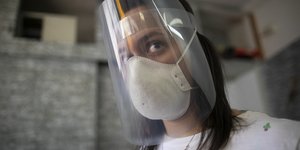 Γυναίκα φορά μάσκα και ασπίδα προστασίας από την μετάδοση του κορωνοϊού