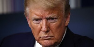 Συνοφρυωμένος ο Ντόλναλντ Τραμπ με σακάκι και κόκκινη γραβάτα