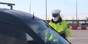 Αστυνομικός με μάσκα πραγματοποιεί ελέγχους στα πλαίσια της επιβολής απαγόρευση κυκλοφορίας