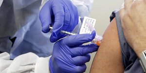 Γιατρός πραγματοποιεί δοκιμή εμβολίου στον ώμο ασθενούς
