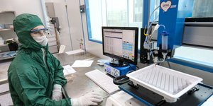 Γυναίκα με στολή, μάσκα και γάντια σε εργαστήριο της Ρωσίας