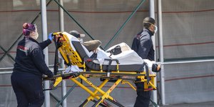 Τραυματιοφορείς μεταφέρουν ασθενή σε φορείο