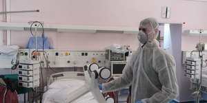 Γιατρός με ειδική στολή δίπλα σε κρεβάτι ΜΕΘ