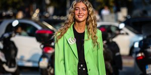 γυναίκα περπατά με σακάκι και τοπ στην εβδομάδα μόδας