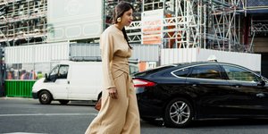 γυναίκα με φόρεμα και σκουλαρίκια περπατά στο δρόμο