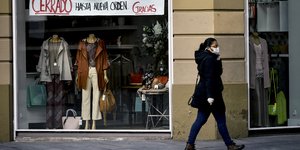 Γυναίκα έξω από βιτρίνα καταστήματος στην Ισπανία