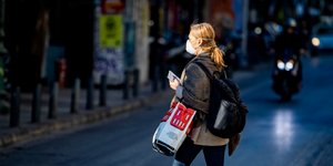 Γυναίκα με μάσκα διασχίζει δρόμο