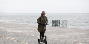 Γυναίκα σε πατίνι μέσα σε βροχή