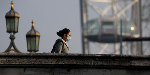 Κορωνοϊός γυναίκα με μάσκα περπατά σε γέφυρα