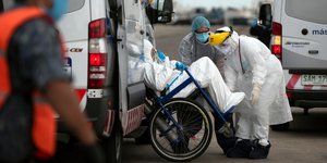 Νοσοκόμοι μεταφέρουν ασθενή με κορωνοϊό