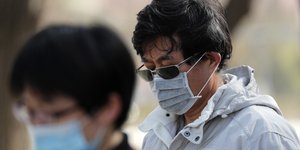 Πολίτες με μάσκες λόγω του κορωνοϊού 