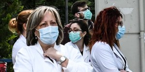 Νοσηλεύτριες έξω από νοσοκομείο στην Ελλάδα, με στολές και μάσκες