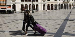 Νεαρό ζευγάρι με βαλίτσες στο κέντρο της Πάτρας