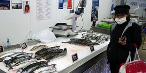 Πολίτης στη Γαλλία με μάσκα ψωνίζει σε ιχθυοπωλείο