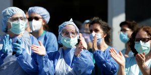 Γιατροί και νοσηλευτές στην Πορτογαλία με μάσκες και προστατευτικές στολές χειροκροτούν