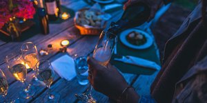 γυναίκα βάζει σαμπάνια σε ποτήρι πάνω σε τραπέζι